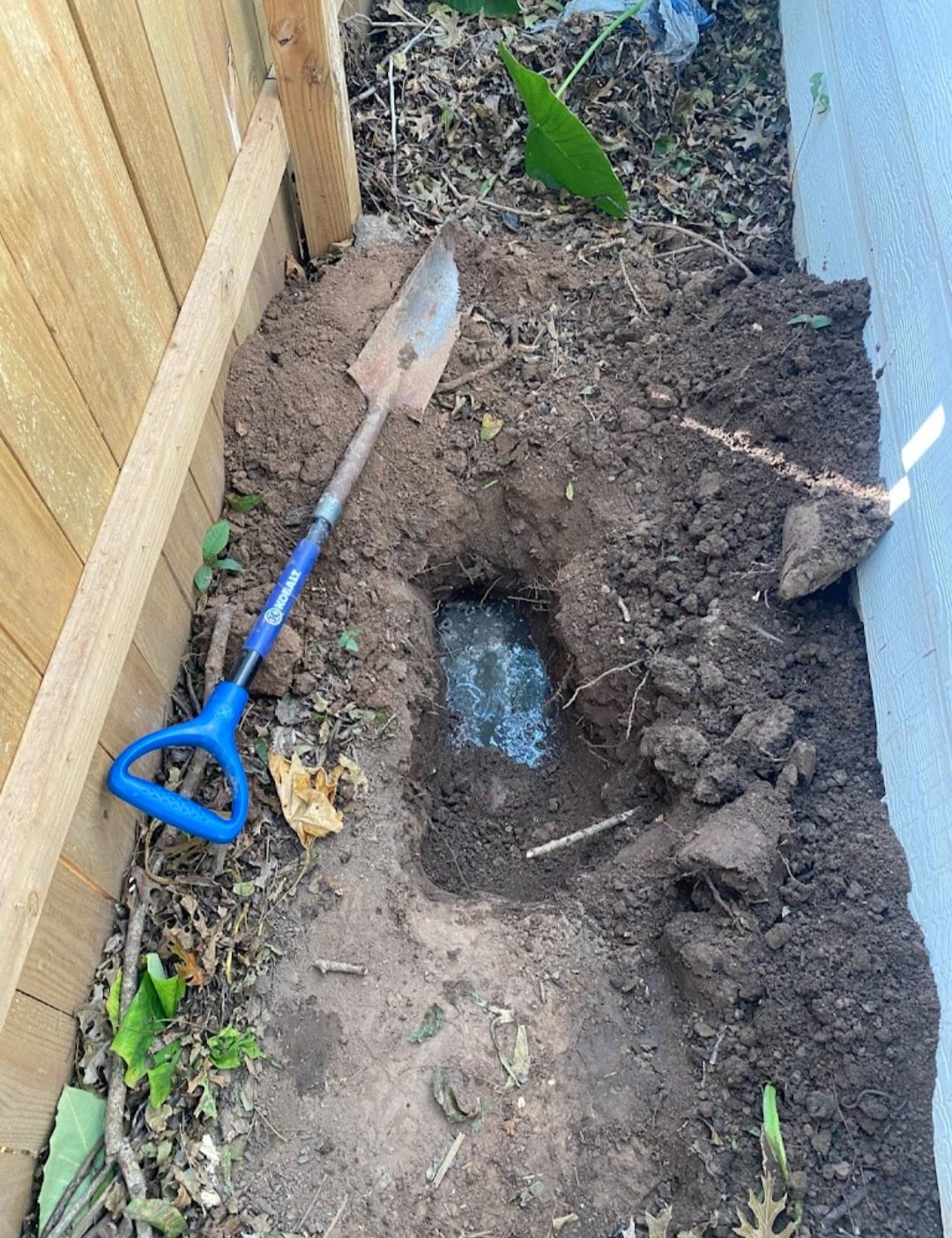 Excavation beside a home while investigating an underground plumbing problem